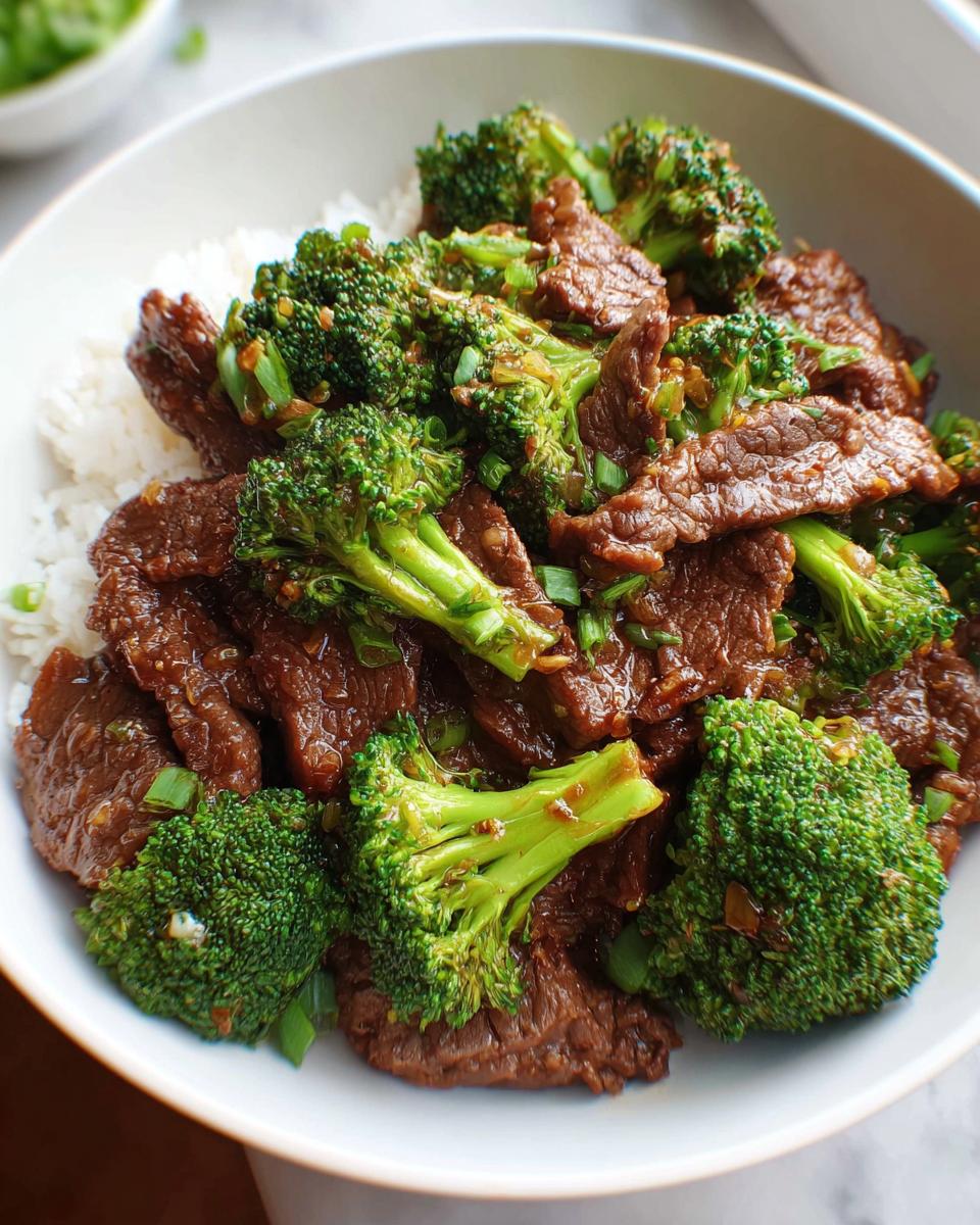 Nahaufnahme von Rindfleisch mit Brokkoli und Reis in einer weißen Schüssel, das Gericht Rindfleisch mit Brokkoli.