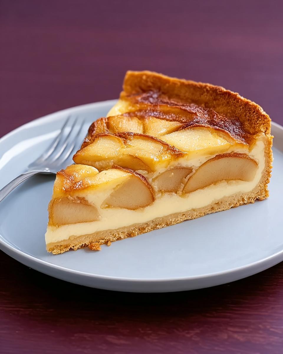 A slice of Finkenwerder Apfelkuchen with baked apple slices on a creamy filling, served on a light blue plate.